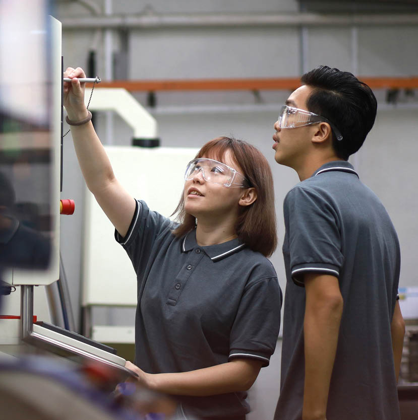 Portrait of Asian Engineers Operating A Machine In Factory.